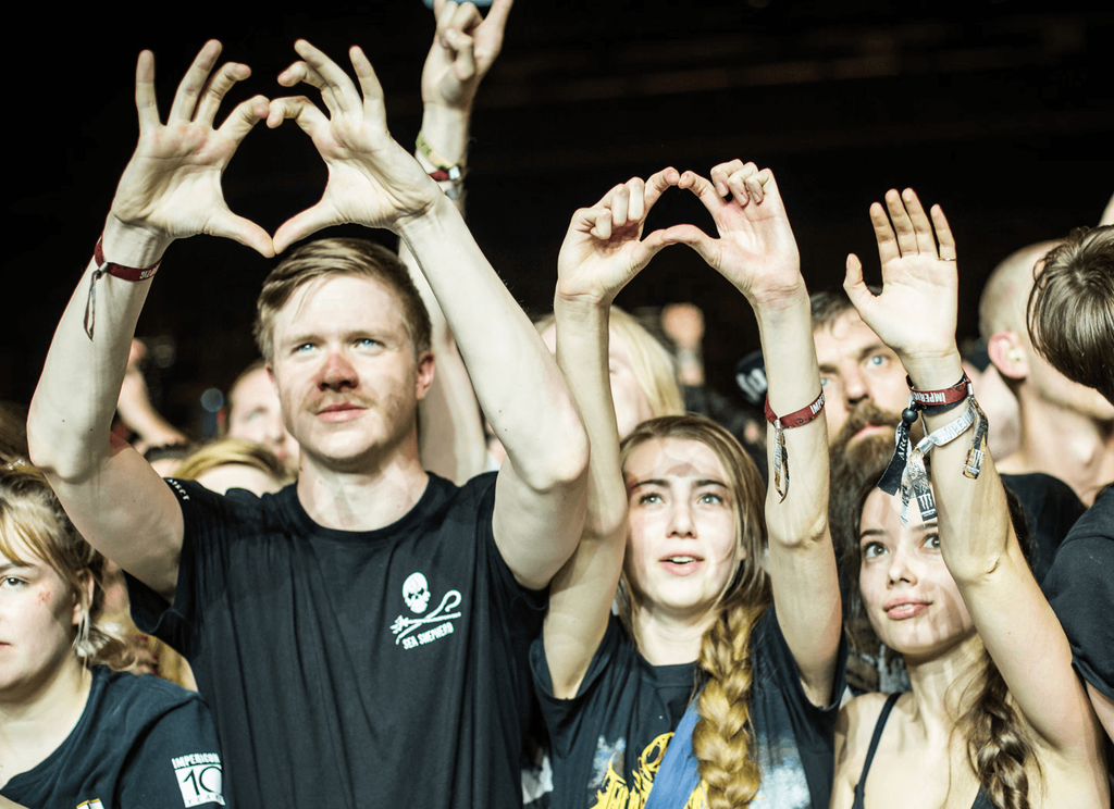 Festivalbesucher, die mit ihren beiden Händen ein Herz formen