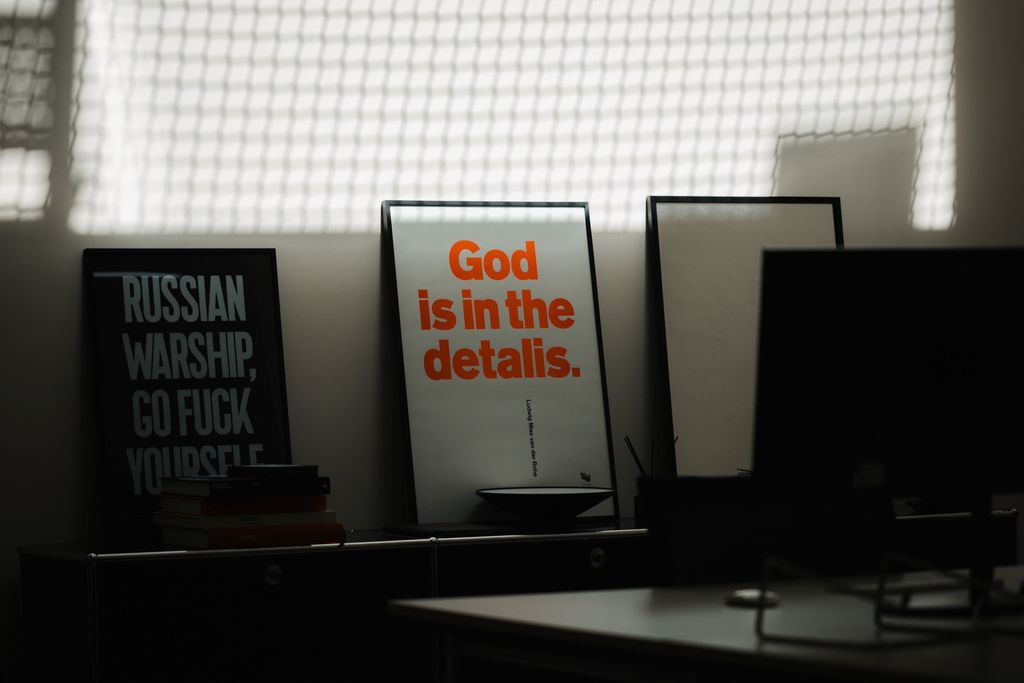 Büroausschnitt, auf dem ein Bilderrahmen mit dem Satz "God is in the details." zu sehen ist