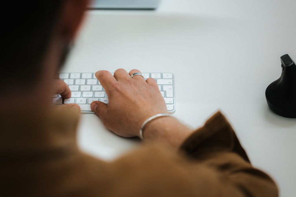 Ein Mann tippt im Büro auf eine Tastatur