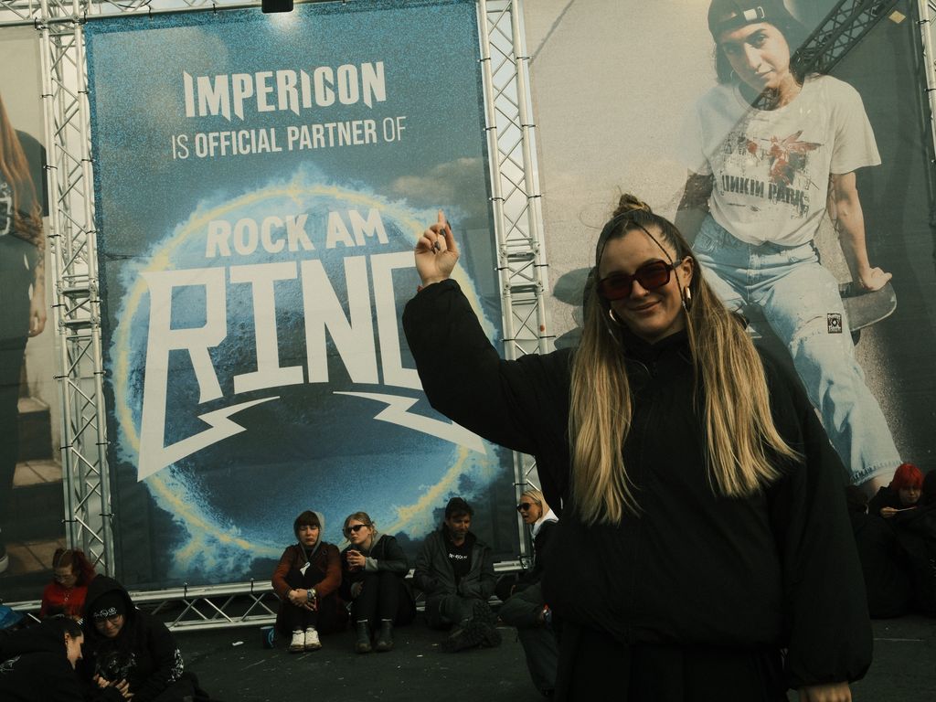 Eine Mitarbeiterin auf dem Rock am Ring Festival vor dem Verkaufsstand von Impericon