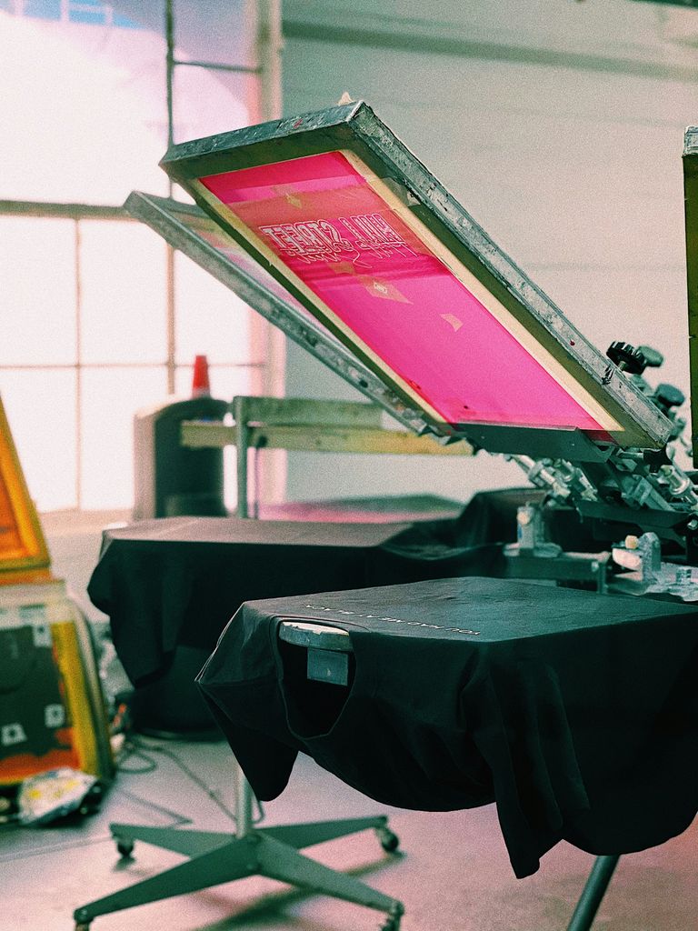 Eine Siebdruckmaschine, auf der gerade ein T-Shirt gedruckt wird.